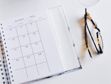 Planner and glasses on desk