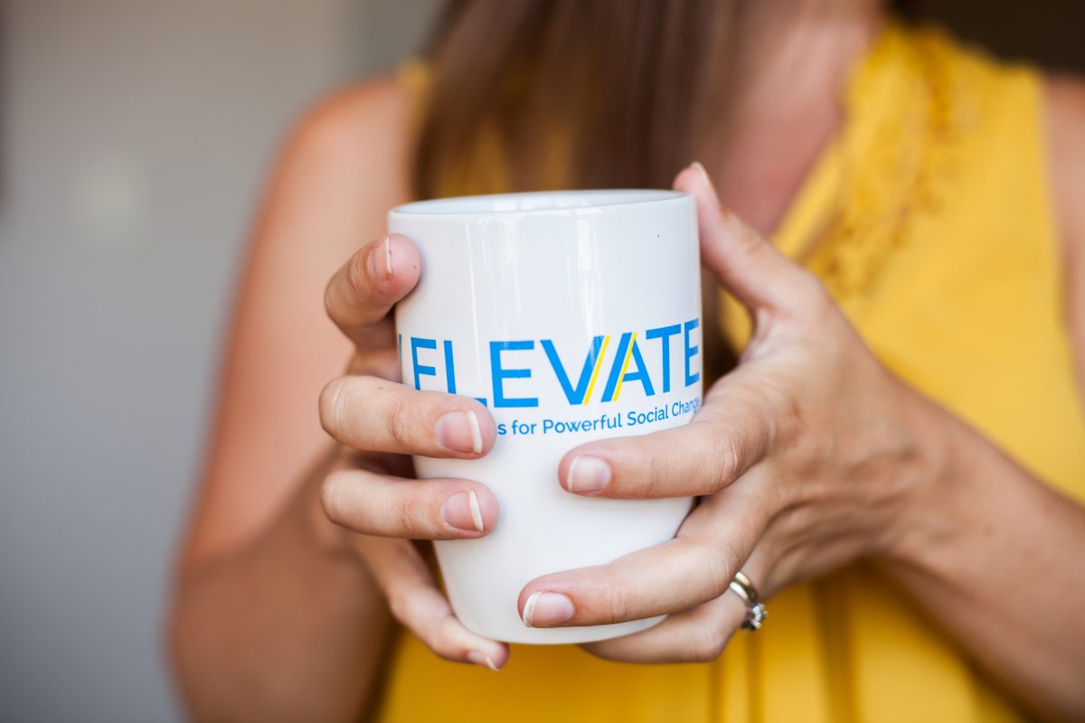 Hands holding an Elevate coffee mug