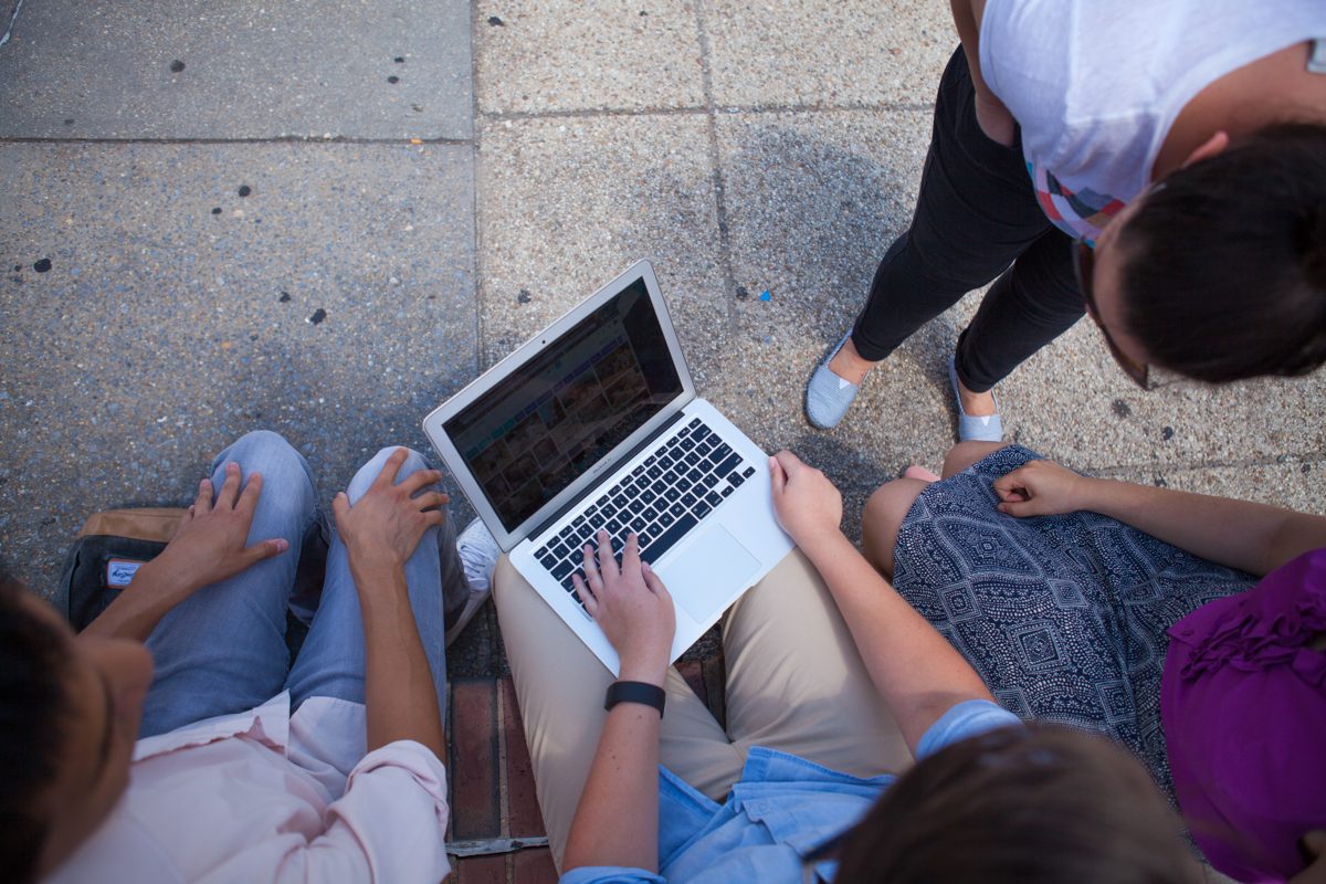 Elevate team members working together around a laptop